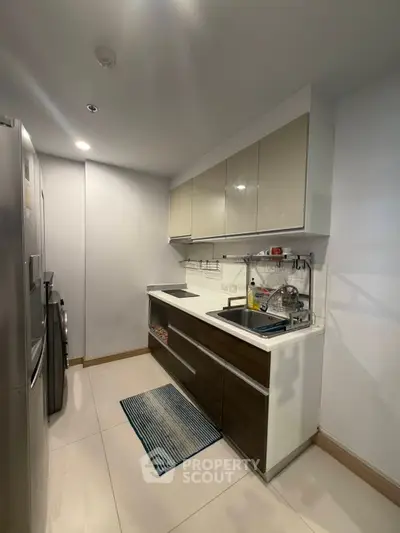Modern kitchen with sleek cabinetry and stainless steel appliances in a compact layout.