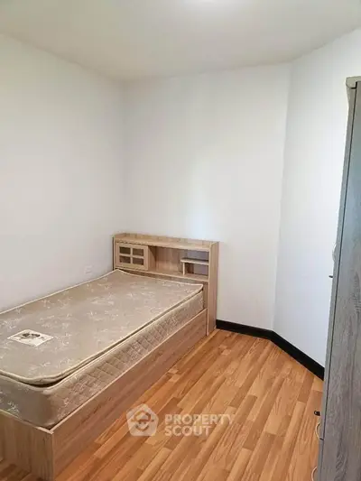 Cozy bedroom with wooden flooring and single bed, perfect for minimalist living.