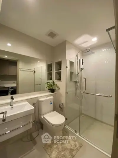 Modern bathroom with glass shower, sleek fixtures, and elegant design.