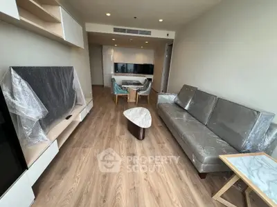 Modern living room with sleek furniture and open layout, featuring a stylish TV setup and elegant flooring.