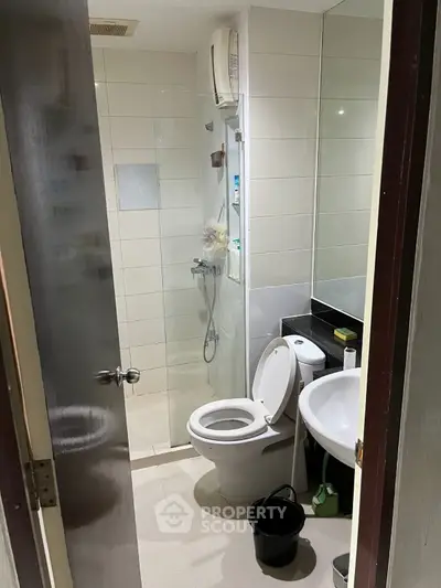 Compact bathroom with shower and modern fixtures, ideal for efficient space use.