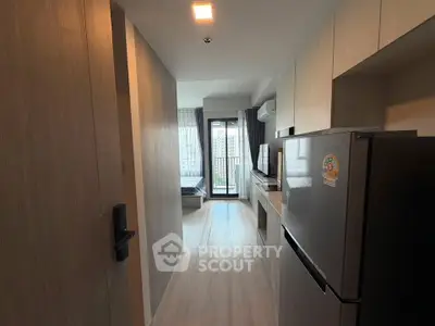 Modern apartment hallway leading to a cozy living area with natural light.