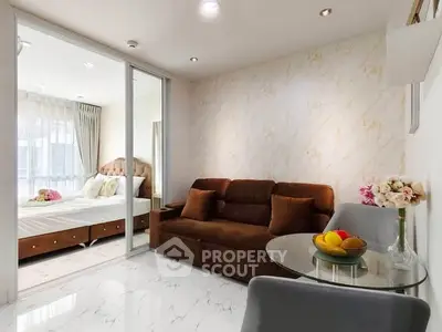 Modern living room with elegant decor and cozy seating adjacent to a stylish bedroom.