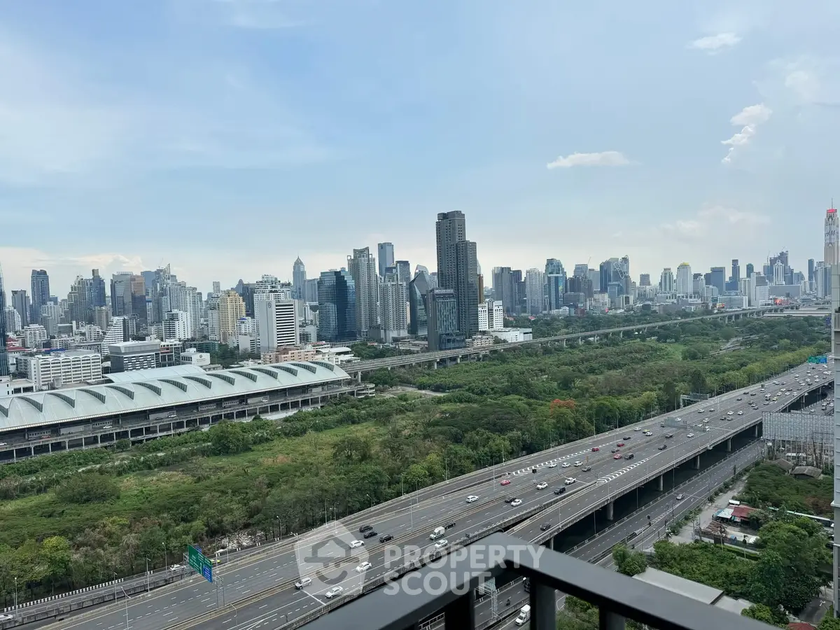 Stunning cityscape view from high-rise balcony overlooking urban skyline and highway.