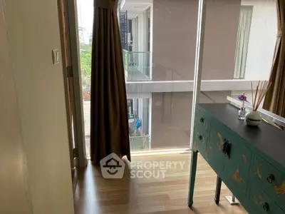 Stylish room with elegant curtains and modern furniture overlooking a serene balcony view.