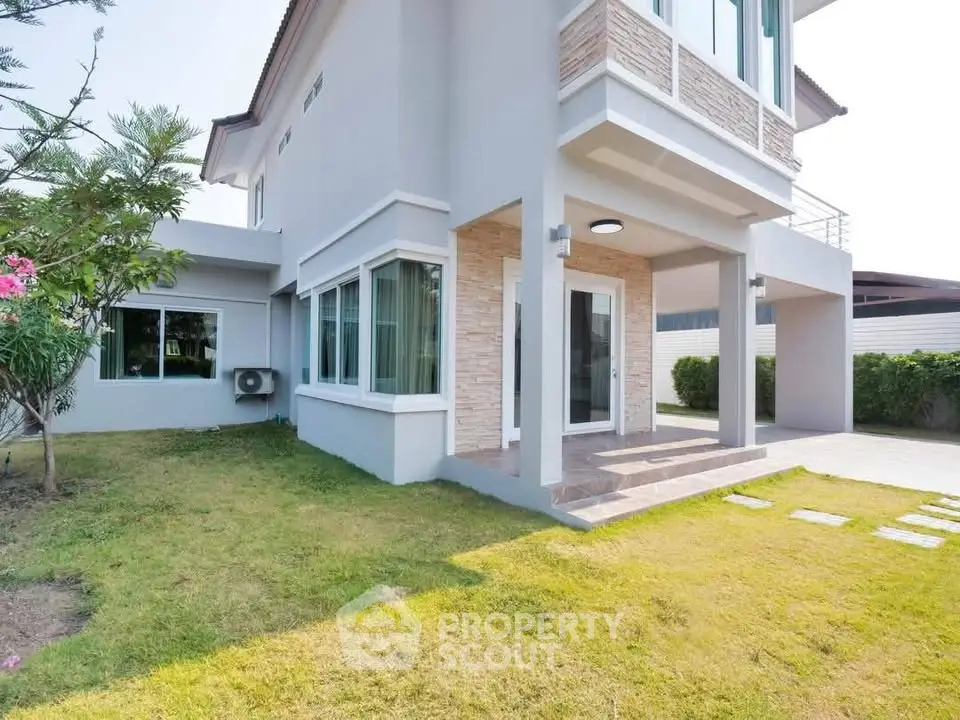 Modern two-story house with spacious garden and elegant exterior design.