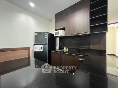 Modern kitchen with sleek black countertops and dark wood cabinetry