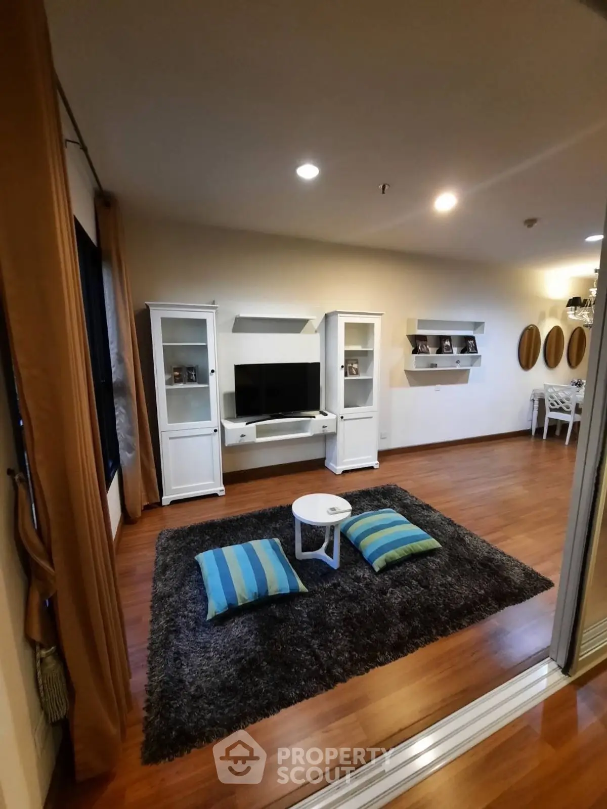 Charming living room with modern decor, wooden flooring, and cozy seating area for relaxation.