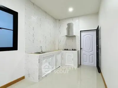 Modern minimalist kitchen with sleek white cabinets and gas stove