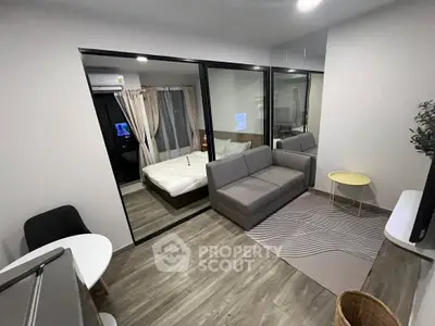 Modern apartment with open layout featuring a cozy living room and adjacent bedroom separated by glass doors.
