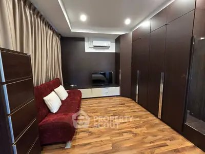 Modern living room with sleek wooden flooring and stylish furniture