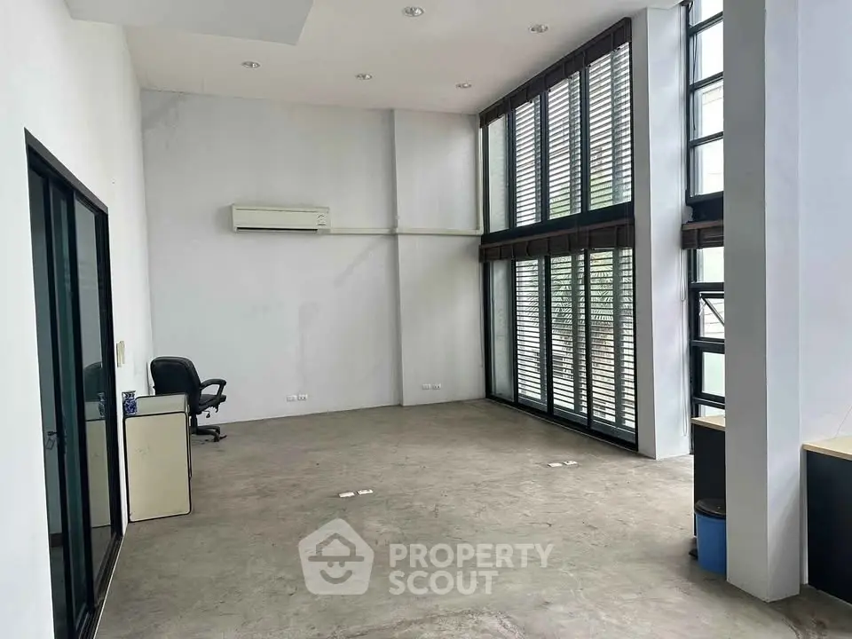 Spacious modern living room with high ceilings and large windows for natural light.
