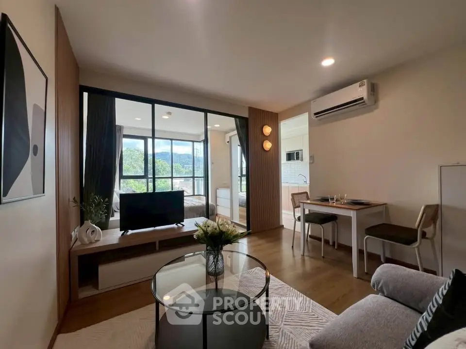 Modern living room with open layout, stylish decor, and natural light in a cozy apartment.