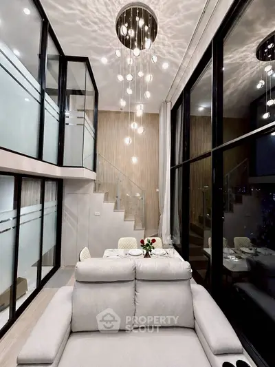 Luxurious modern living room with high ceilings and elegant chandelier in a stylish duplex apartment.