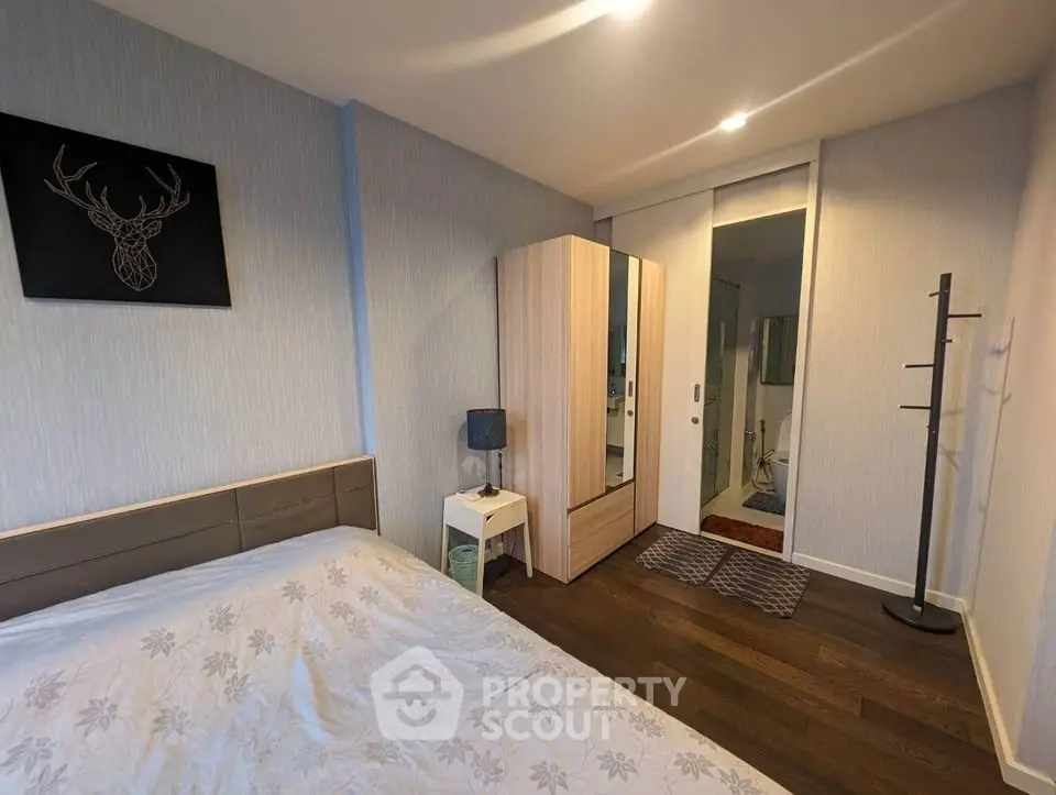 Modern bedroom with stylish decor and ensuite bathroom in a cozy apartment.