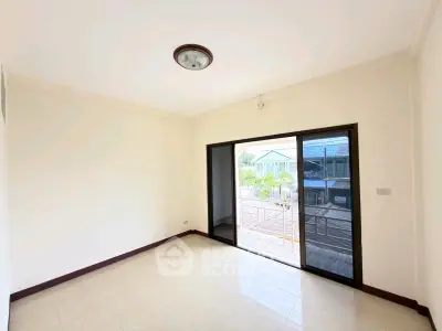 Bright empty room with large sliding glass doors leading to a balcony, offering ample natural light and outdoor access.