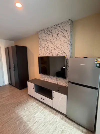 Modern living room with stylish TV unit and refrigerator, featuring elegant wood flooring and contemporary design.
