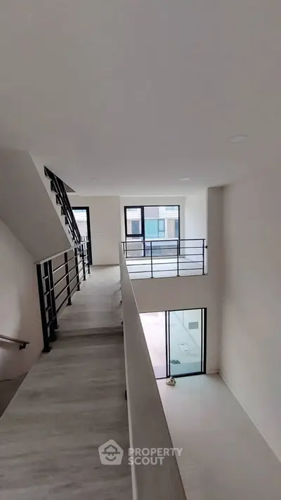 Spacious modern interior with sleek staircase and large windows for natural light.