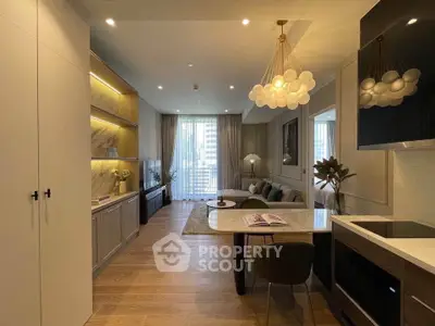 Modern living room with elegant decor and open kitchen layout, featuring stylish lighting and cozy seating area.