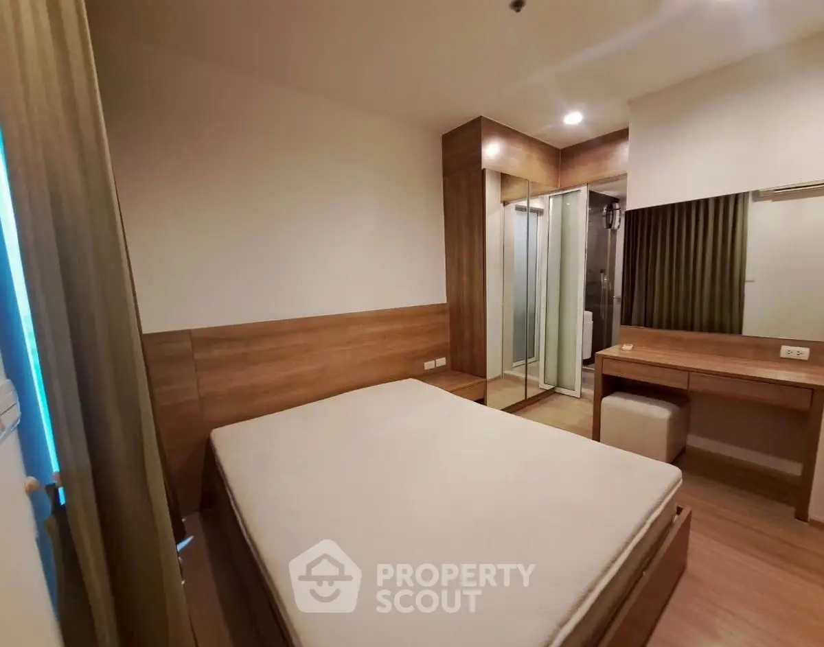 Modern bedroom with wooden furniture and ensuite bathroom in a cozy apartment.