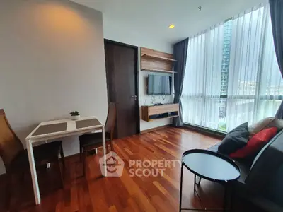 Modern living room with hardwood floors, large window, and stylish furniture in a high-rise apartment.