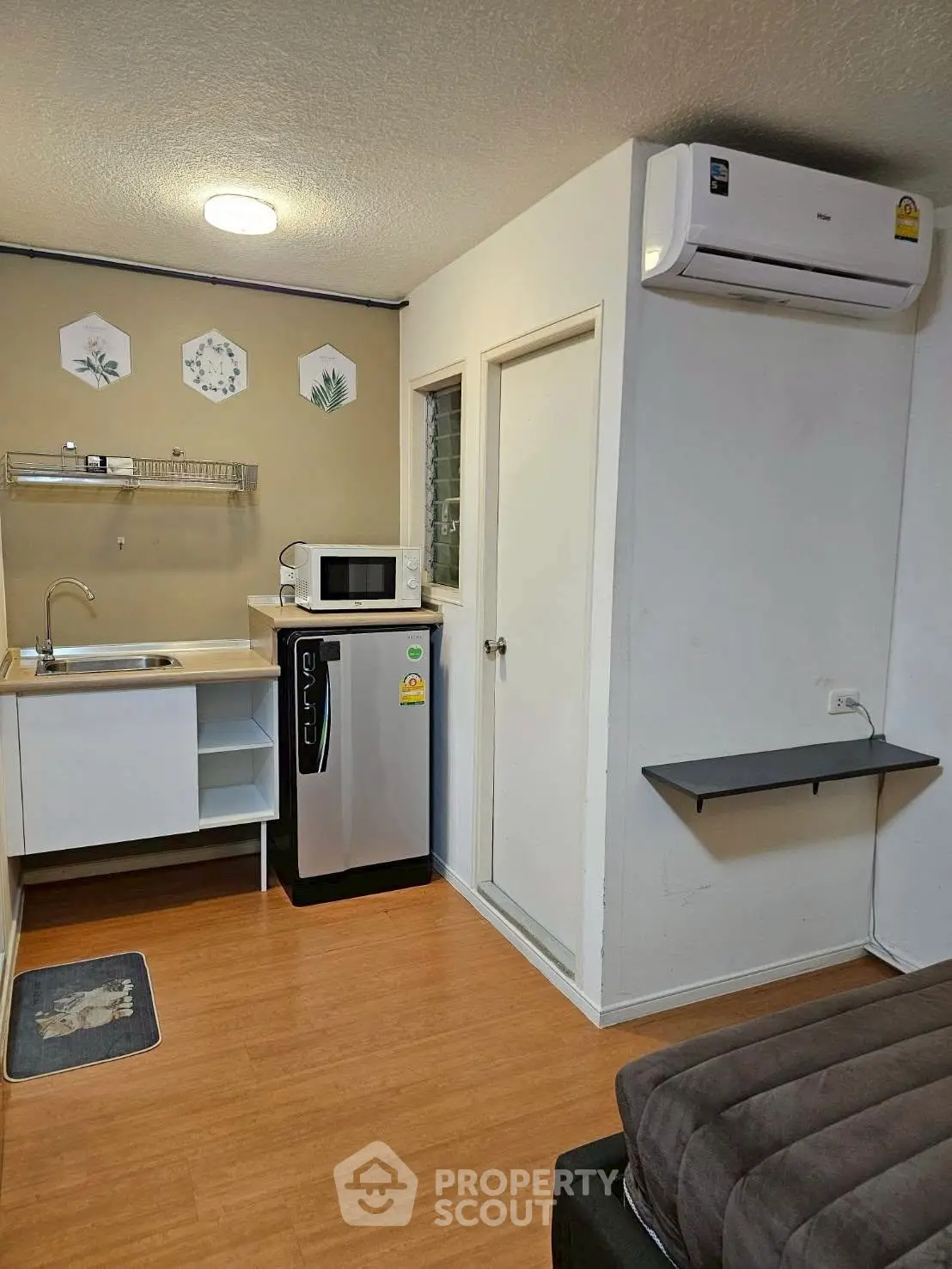 Cozy studio apartment with compact kitchen and modern appliances, perfect for urban living.
