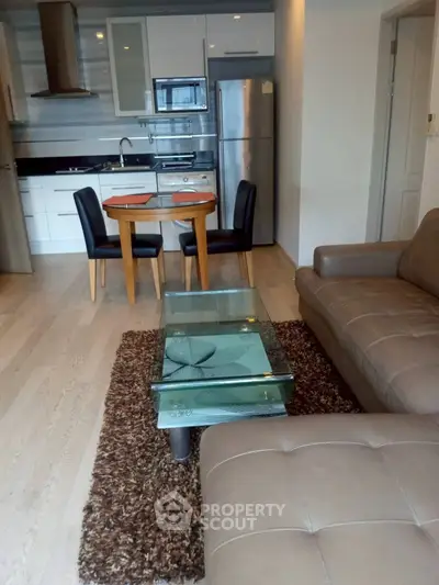 Modern open-layout kitchen and living room with sleek furniture and appliances.