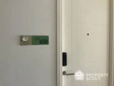 Modern apartment door with electronic lock and room number 302