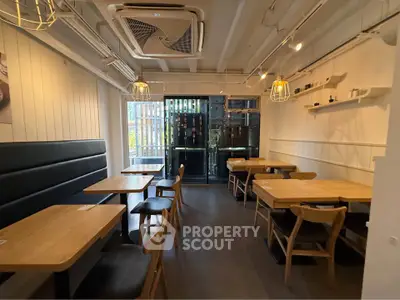 Chic modern dining area with stylish wooden tables and chairs, perfect for cozy gatherings.