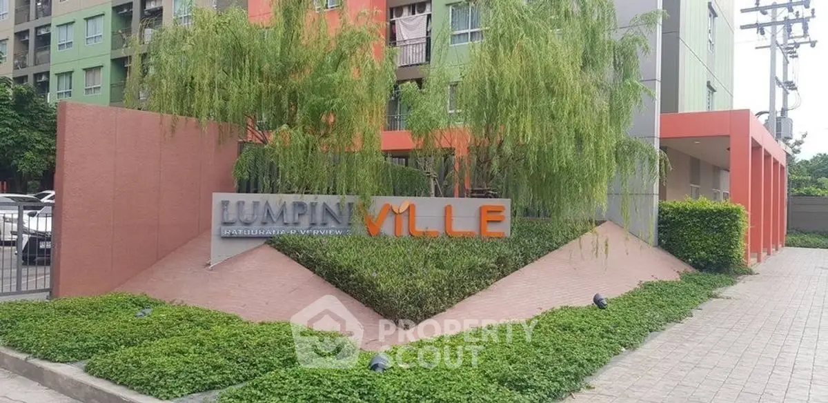 Modern Lumpin Ville apartment entrance with lush greenery and contemporary design.