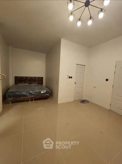 Spacious bedroom with modern lighting and tiled flooring