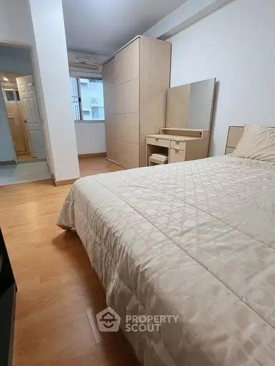 Cozy bedroom with elegant wooden furniture and soft lighting, perfect for relaxation and comfort.