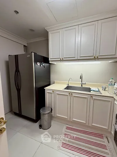 Charming kitchen with modern fridge and elegant cabinetry, perfect for culinary enthusiasts.