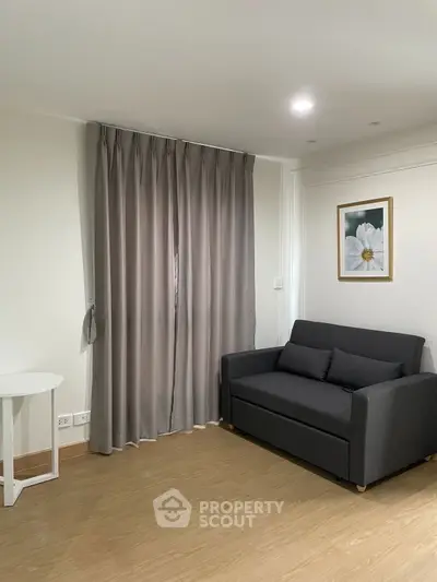 Cozy living room with modern sofa and elegant curtains, perfect for relaxation.