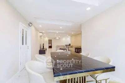 Spacious modern living room with elegant dining area and luxurious marble table.