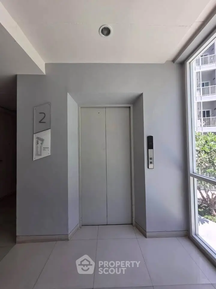 Modern building elevator lobby with natural light and sleek design.