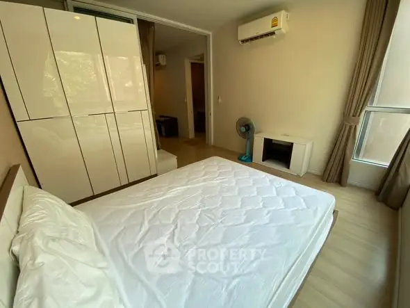 Modern bedroom with sleek wardrobe and air conditioning in a cozy apartment.