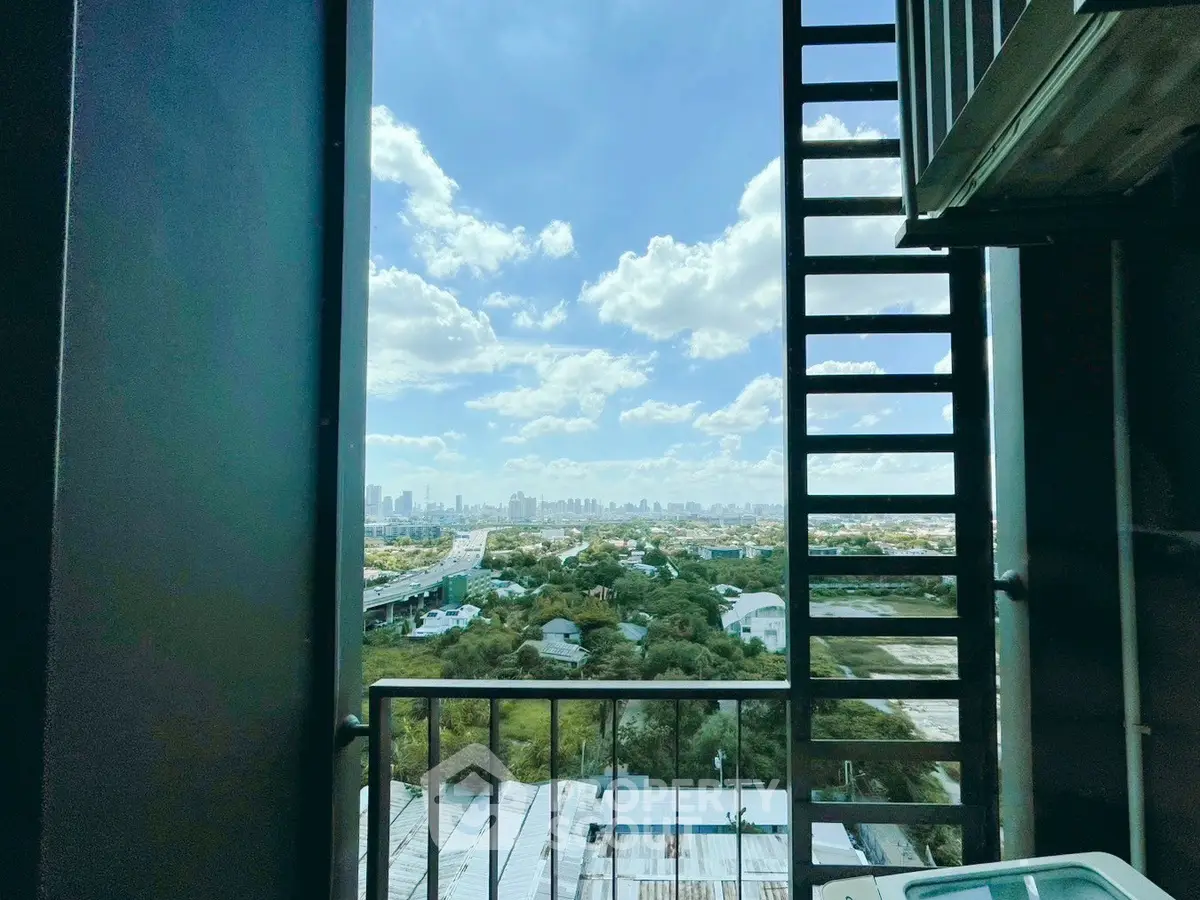 Stunning cityscape view from a high-rise balcony with clear blue skies and lush greenery.
