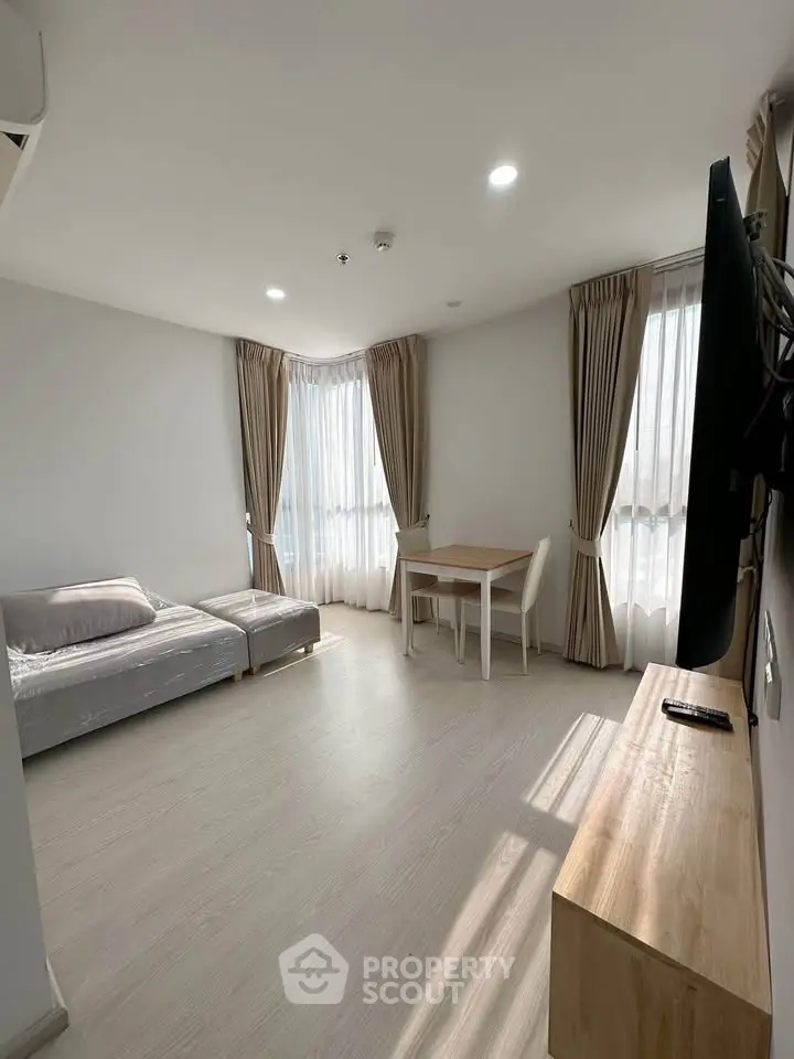 Bright and airy living room with modern furnishings and large windows in a stylish apartment.