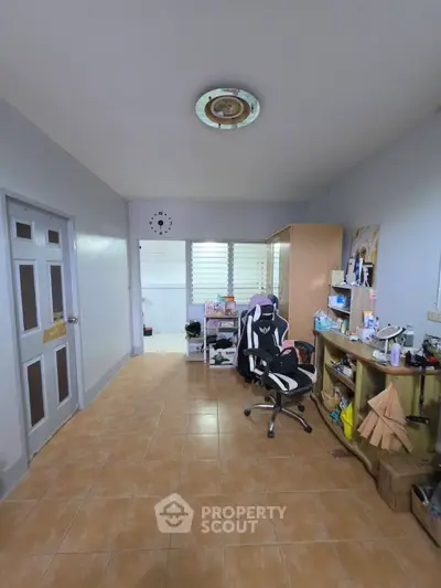 Spacious study room with modern gaming chair and ample storage in a cozy home setting.