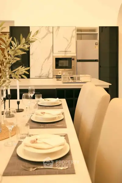 Luxurious modern kitchen with elegant dining setup and marble accents.