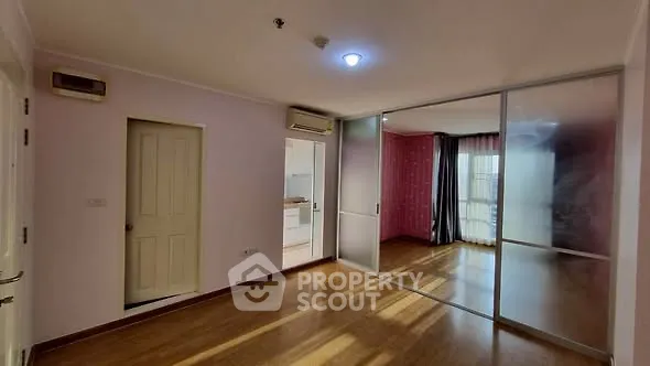 Spacious apartment with sliding glass doors and wooden flooring, ideal for modern living.