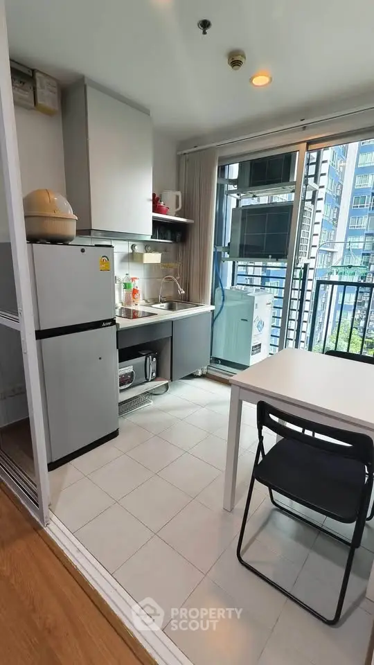 Modern compact kitchen with balcony view in urban apartment