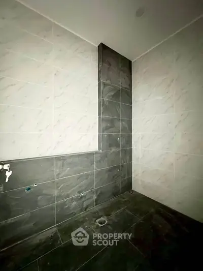 Modern bathroom with sleek dark tiles and marble accents, ready for customization.
