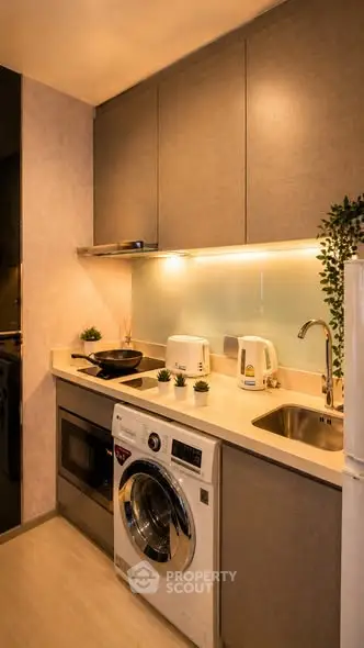 Modern kitchen with sleek appliances and washing machine in compact layout