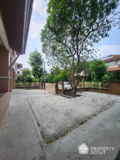 Spacious residential driveway with lush greenery and ample parking space.