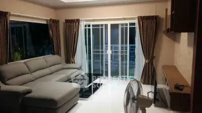 Spacious living room with modern sofa and large windows for natural light.