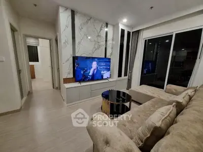Luxurious living room with modern decor and large TV, perfect for relaxation and entertainment.
