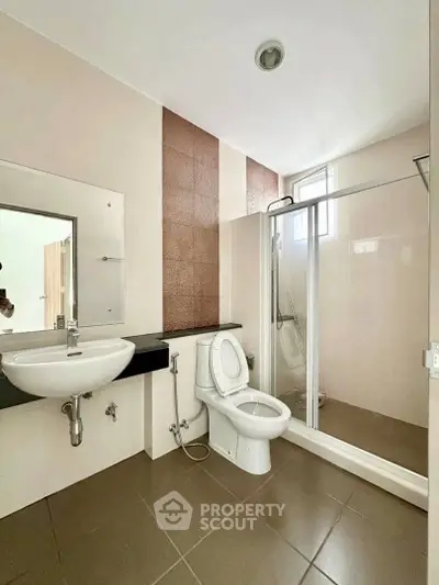 Modern bathroom with glass shower and sleek fixtures in a contemporary home.
