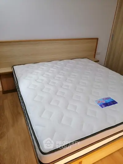 Spacious bedroom with modern wooden bed frame and comfortable mattress
